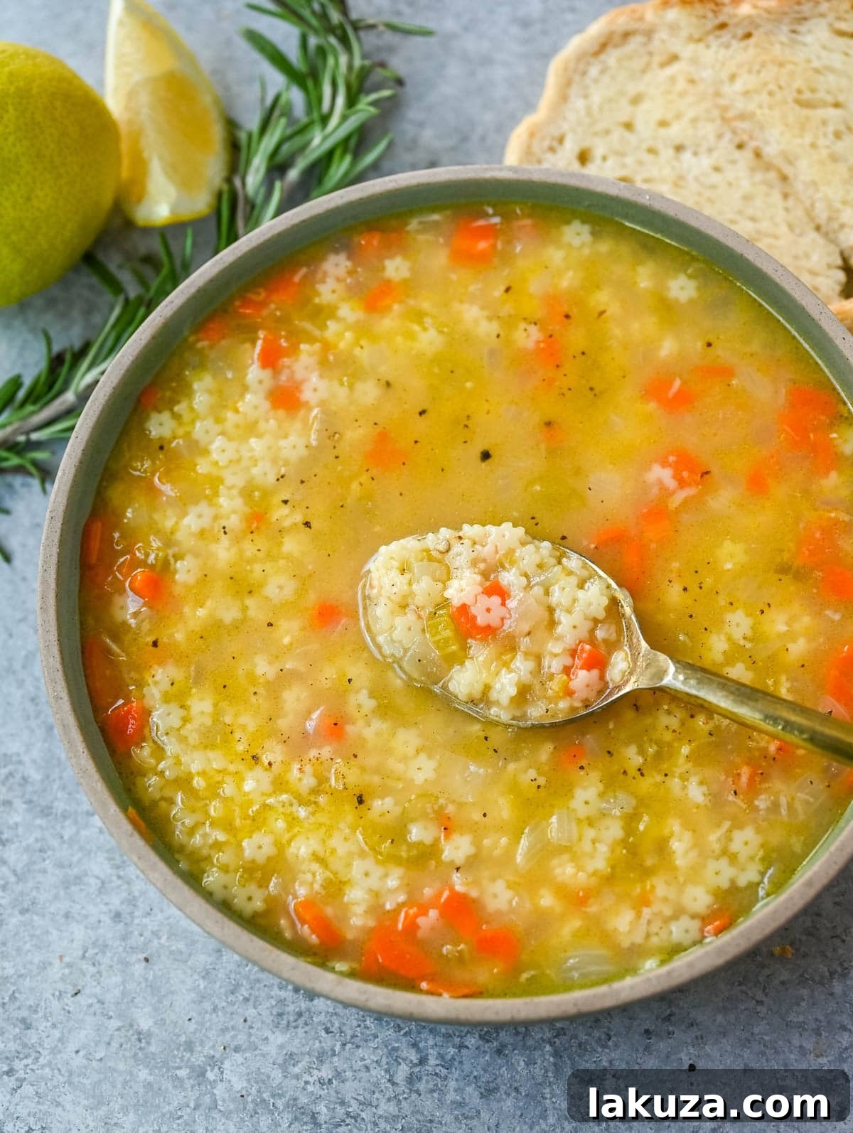 Heartwarming Italian Pastina Soup 3 Close-up of Pastina Soup in a white bowl, showing the delicate star-shaped pasta and a sprinkle of Parmesan cheese.