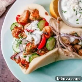 Delicious Greek Chicken Gyros with marinated chicken, homemade tzatziki sauce, and fresh salad in warm pita.