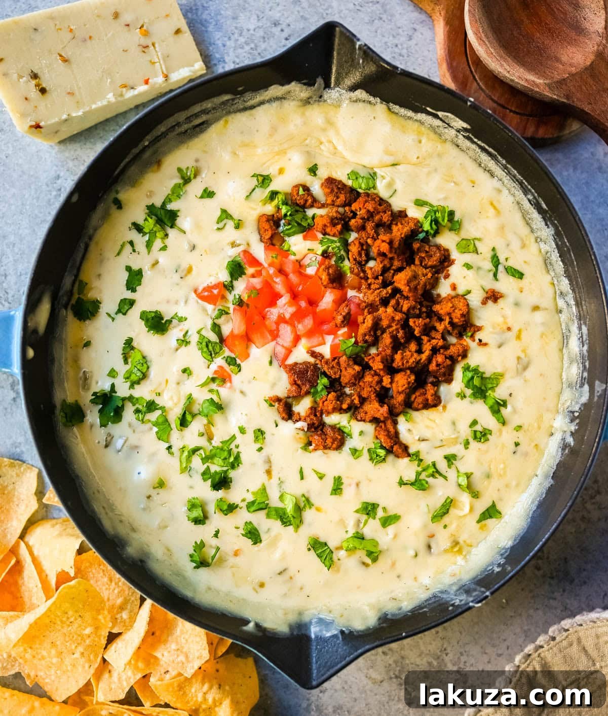 Ultimate Creamy Queso Dip 2 A large bowl of creamy white queso dip garnished with cilantro, ready to be served with tortilla chips.