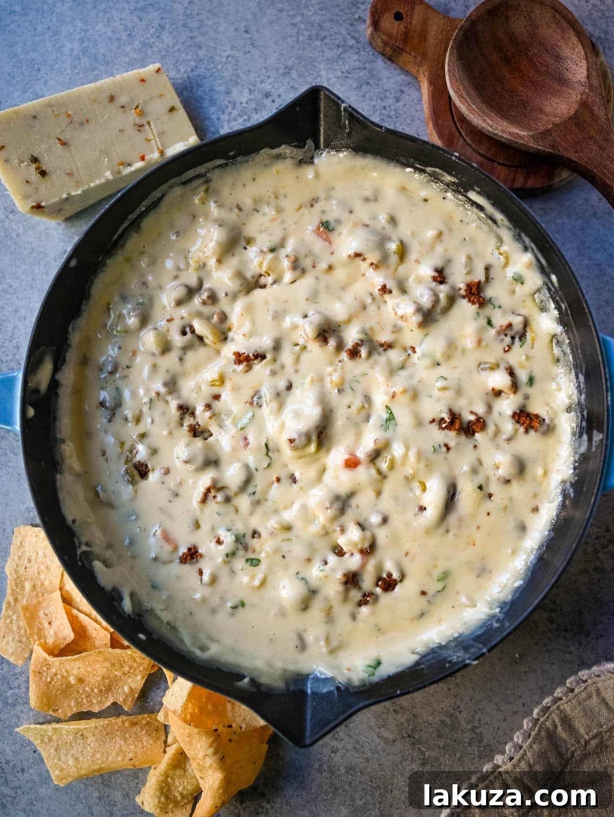 Ultimate Creamy Queso Dip 5 A cast-iron skillet filled with homemade green chile queso, topped with crumbled chorizo and fresh cilantro.