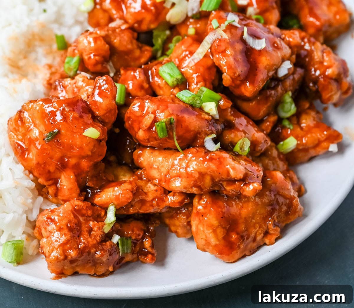 Sticky Honey Sriracha Chicken 6 Honey Sriracha Chicken served in a bowl with a side of Asian noodles and fresh cilantro, offering a complete meal idea.