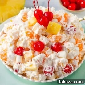 The Best Ambrosia Salad is a fluffy salad made with fresh pineapple, mandarin oranges, maraschino cherries, coconut, marshmallows, fresh whipped cream, a touch of sour cream, and sugar. This is a nostalgic, classic side dish or dessert recipe.