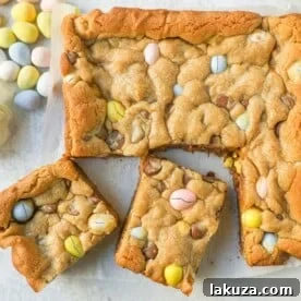 Chewy milk chocolate chip cookie bars filled with mini Cadbury eggs, perfect for Easter.