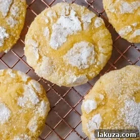 Soft chewy lemon cookies with fresh lemon juice, zest, and extract, rolled in powdered sugar.