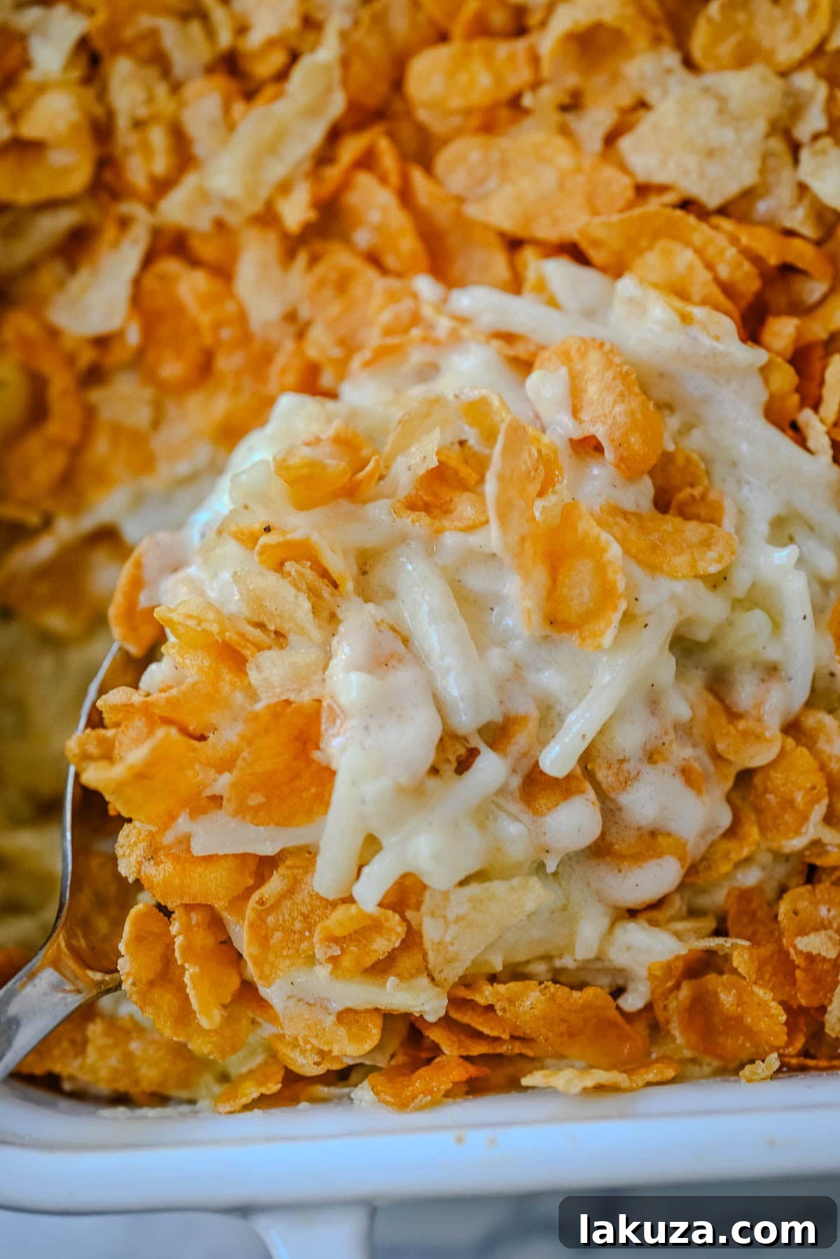 Hearty Cheesy Potato Casserole 3 A whole baking dish of homemade Funeral Potatoes, freshly baked and ready to be served, showcasing the rich, bubbly potato base and crunchy cornflake crust.