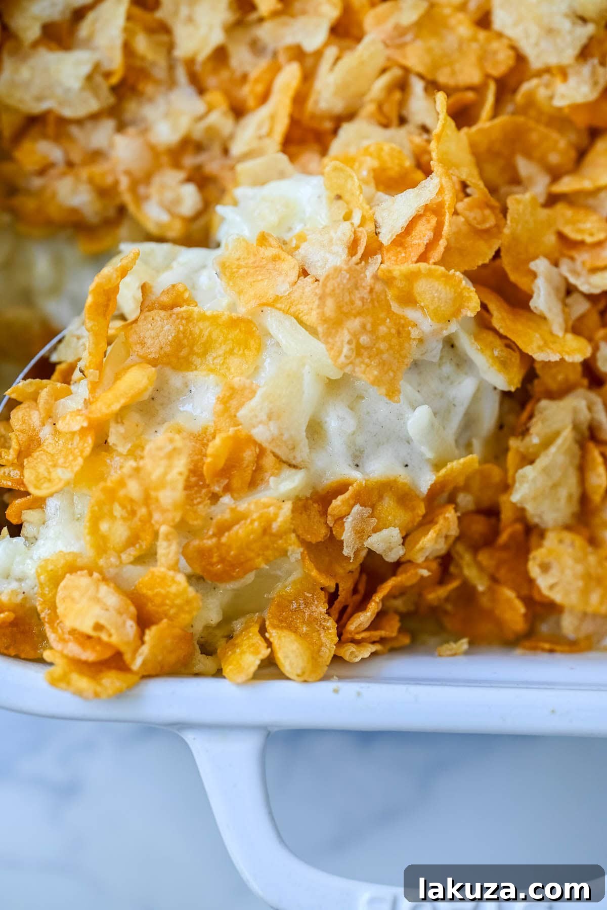 Hearty Cheesy Potato Casserole 5 A detailed view of the layered ingredients of Funeral Potatoes, with melted cheese and hash browns, before baking, promising a rich and flavorful outcome.