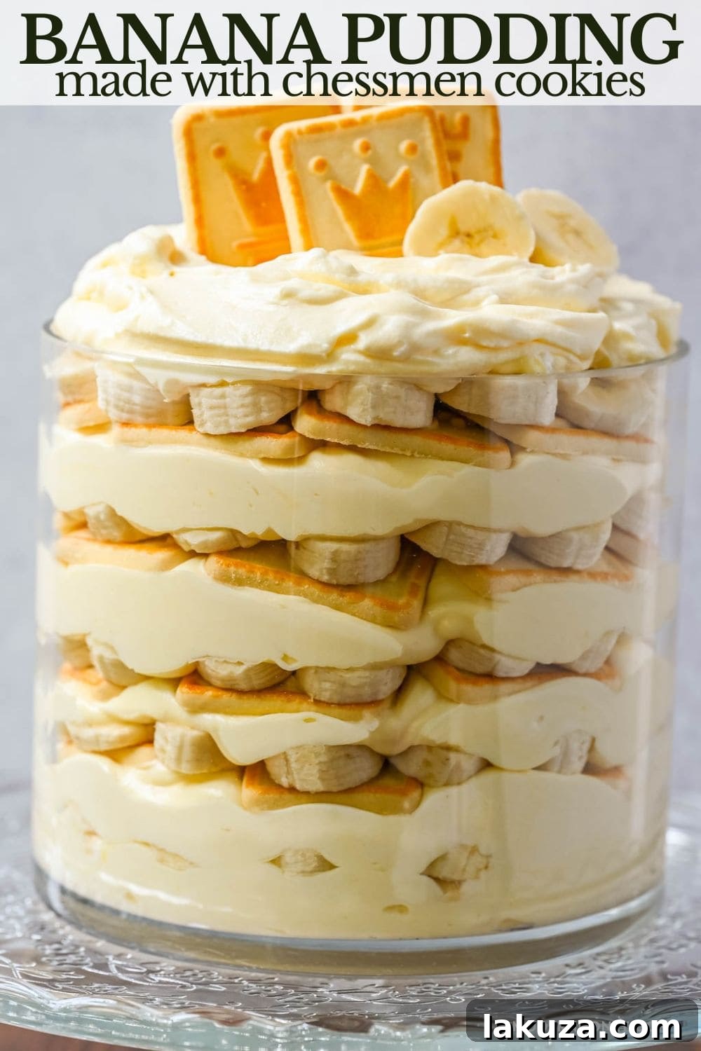Overhead view of a large bowl of no-bake banana pudding with Chessmen cookies, topped with whipped cream and crushed cookies.