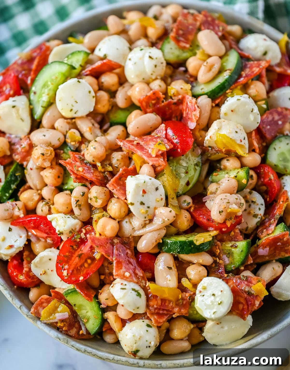 This Italian dense bean salad is the TikTok viral high protein meal prep recipe that has taken over the internet and for very good reason. Loaded with chickpeas, white beans, crisp Persian cucumbers, cherry tomatoes, creamy mozzarella, savory pepperoni or salami, and tangy pepperoncinis all tossed in a homemade Italian dressing, every single bite is packed with incredible flavor that gets better the longer it sits.