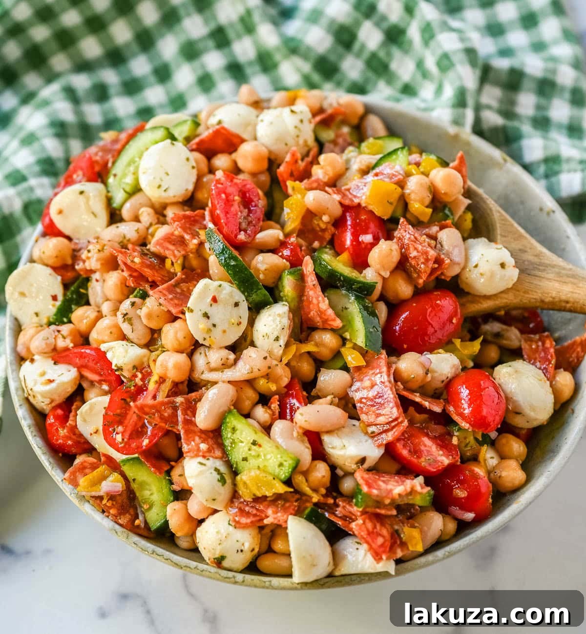 This Italian dense bean salad is the TikTok viral high protein meal prep recipe that has taken over the internet and for very good reason. Loaded with chickpeas, white beans, crisp Persian cucumbers, cherry tomatoes, creamy mozzarella, savory pepperoni or salami, and tangy pepperoncinis all tossed in a homemade Italian dressing, every single bite is packed with incredible flavor that gets better the longer it sits.