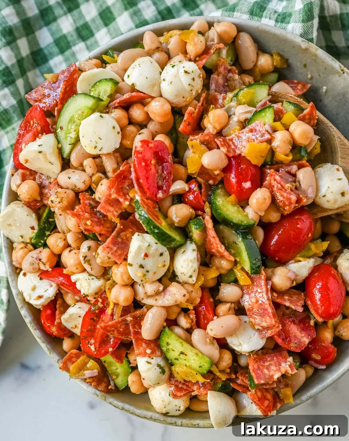 This Italian dense bean salad is the TikTok viral high protein meal prep recipe that has taken over the internet and for very good reason. Loaded with chickpeas, white beans, crisp Persian cucumbers, cherry tomatoes, creamy mozzarella, savory pepperoni or salami, and tangy pepperoncinis all tossed in a homemade Italian dressing, every single bite is packed with incredible flavor that gets better the longer it sits.