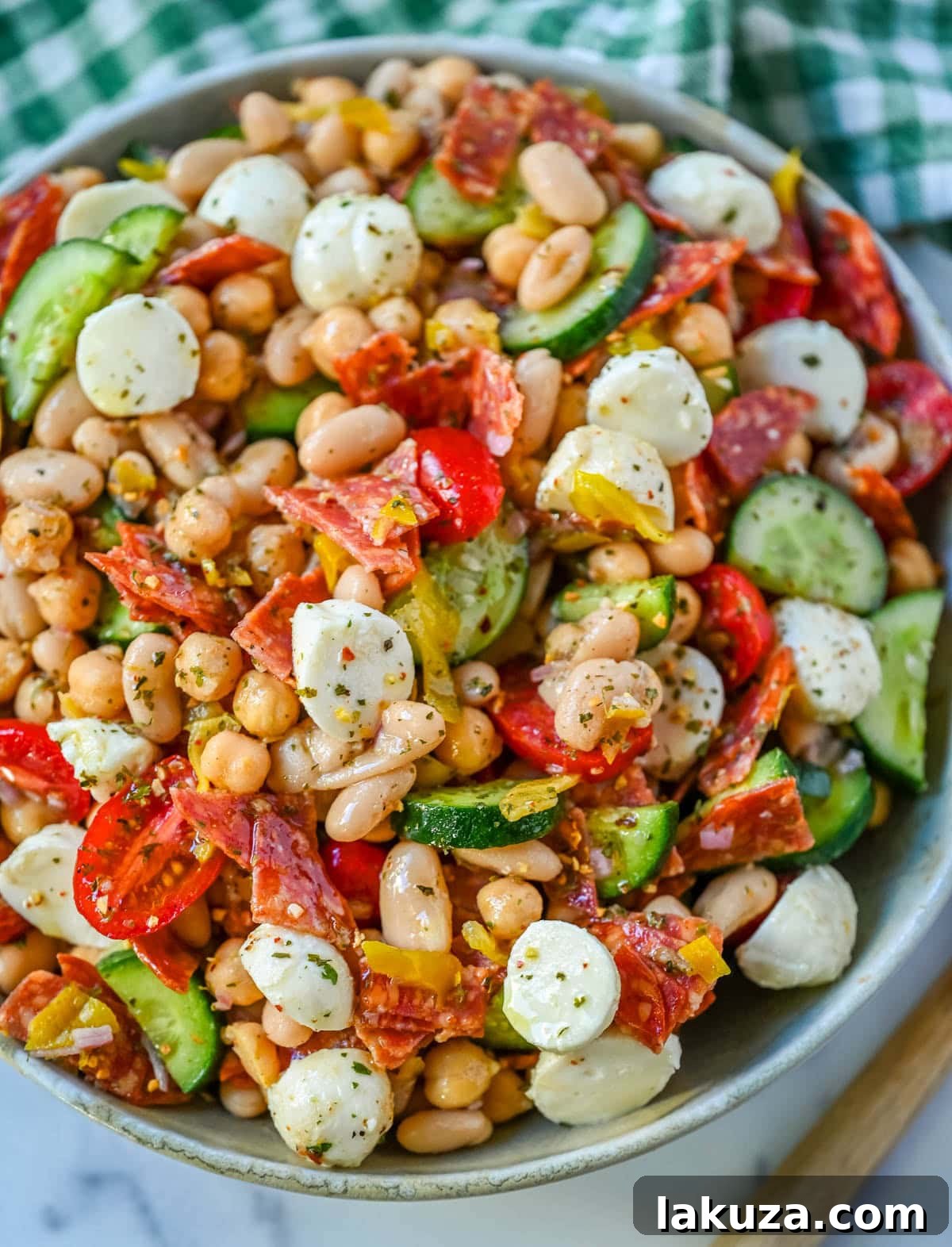 This Italian dense bean salad is the TikTok viral high protein meal prep recipe that has taken over the internet and for very good reason. Loaded with chickpeas, white beans, crisp Persian cucumbers, cherry tomatoes, creamy mozzarella, savory pepperoni or salami, and tangy pepperoncinis all tossed in a homemade Italian dressing, every single bite is packed with incredible flavor that gets better the longer it sits.