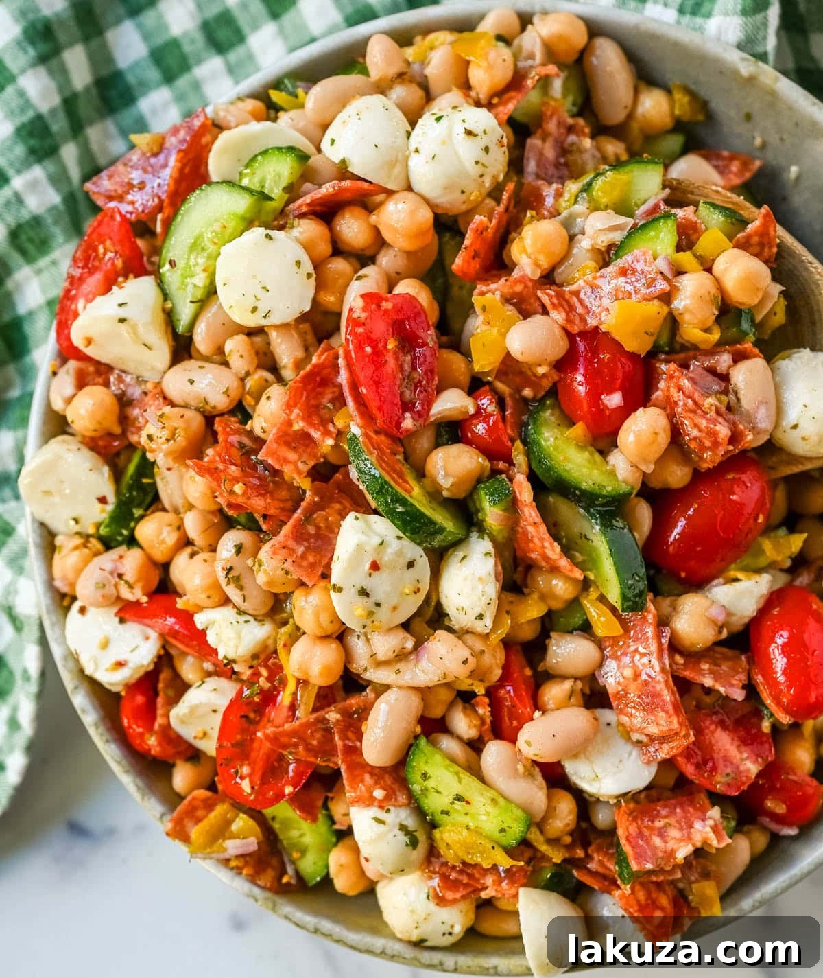 This Italian dense bean salad is the TikTok viral high protein meal prep recipe that has taken over the internet and for very good reason. Loaded with chickpeas, white beans, crisp Persian cucumbers, cherry tomatoes, creamy mozzarella, savory pepperoni or salami, and tangy pepperoncinis all tossed in a homemade Italian dressing, every single bite is packed with incredible flavor that gets better the longer it sits.