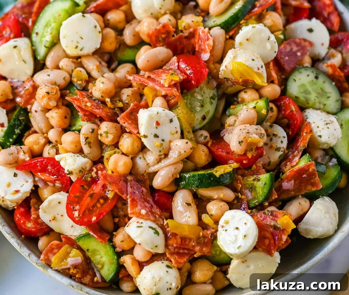 This Italian dense bean salad is the TikTok viral high protein meal prep recipe that has taken over the internet and for very good reason. Loaded with chickpeas, white beans, crisp Persian cucumbers, cherry tomatoes, creamy mozzarella, savory pepperoni or salami, and tangy pepperoncinis all tossed in a homemade Italian dressing, every single bite is packed with incredible flavor that gets better the longer it sits.