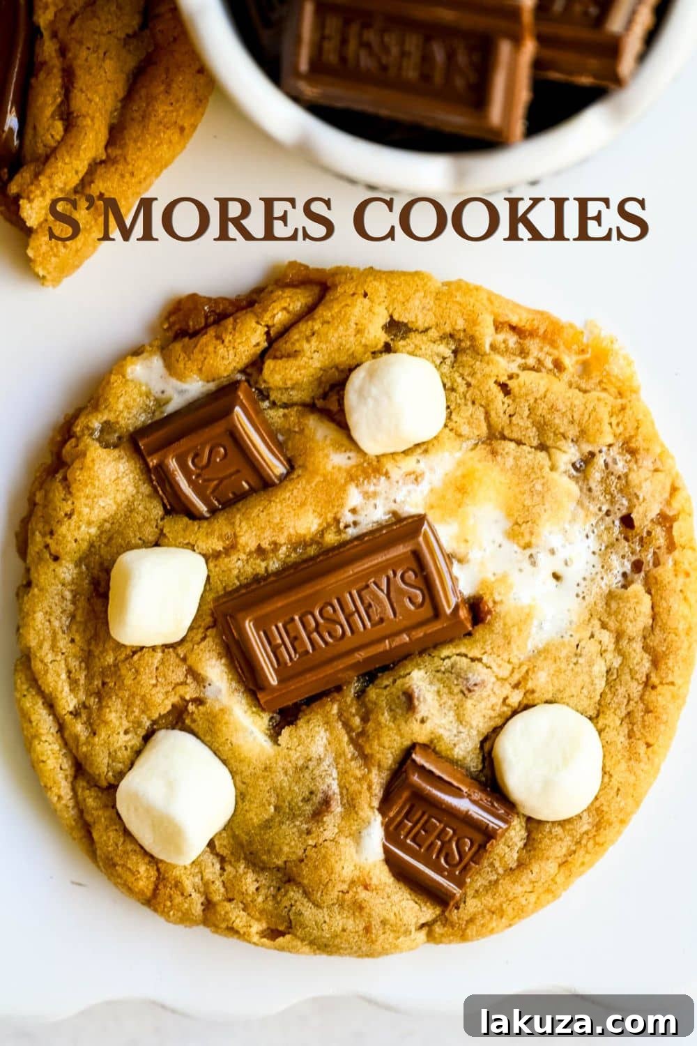 The best s'mores cookie recipe made with graham cracker dough, Hershey's chocolate, and marshmallows baked in and piled on top. These homemade smores cookies are ooey, chewy, and so easy. This easy s'mores cookie recipe comes together in just one bowl.