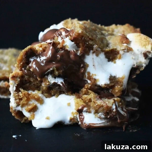 S'mores Bars made with homemade graham cracker cookie dough, marshmallow fluff, and milk chocolate bars.