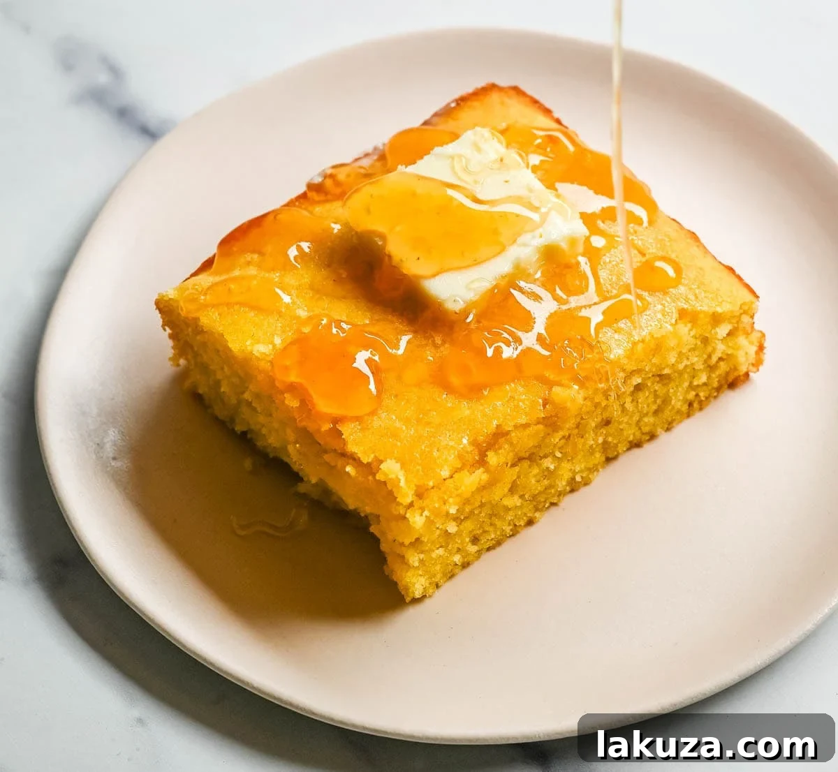 This moist and fluffy hot honey cornbread is sweet, slightly spicy, and absolutely packed with flavor from the very first bite!  This is the most irresistible cornbread topped with hot honey butter you will ever make, and it comes together in just one bowl in under 30 minutes, making it the easiest and most flavorful side dish.