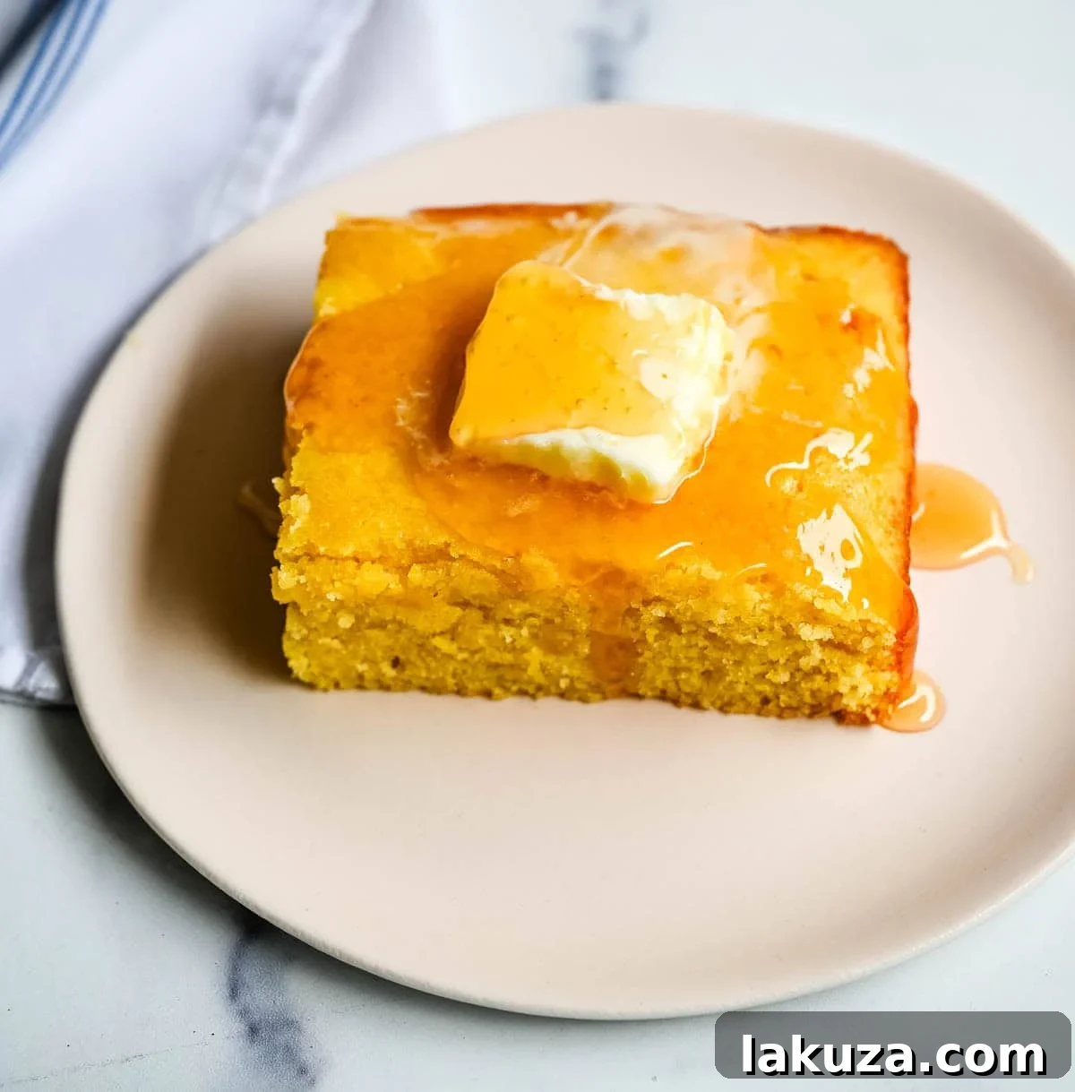 This moist and fluffy hot honey cornbread is sweet, slightly spicy, and absolutely packed with flavor from the very first bite!  This is the most irresistible cornbread topped with hot honey butter you will ever make, and it comes together in just one bowl in under 30 minutes, making it the easiest and most flavorful side dish.