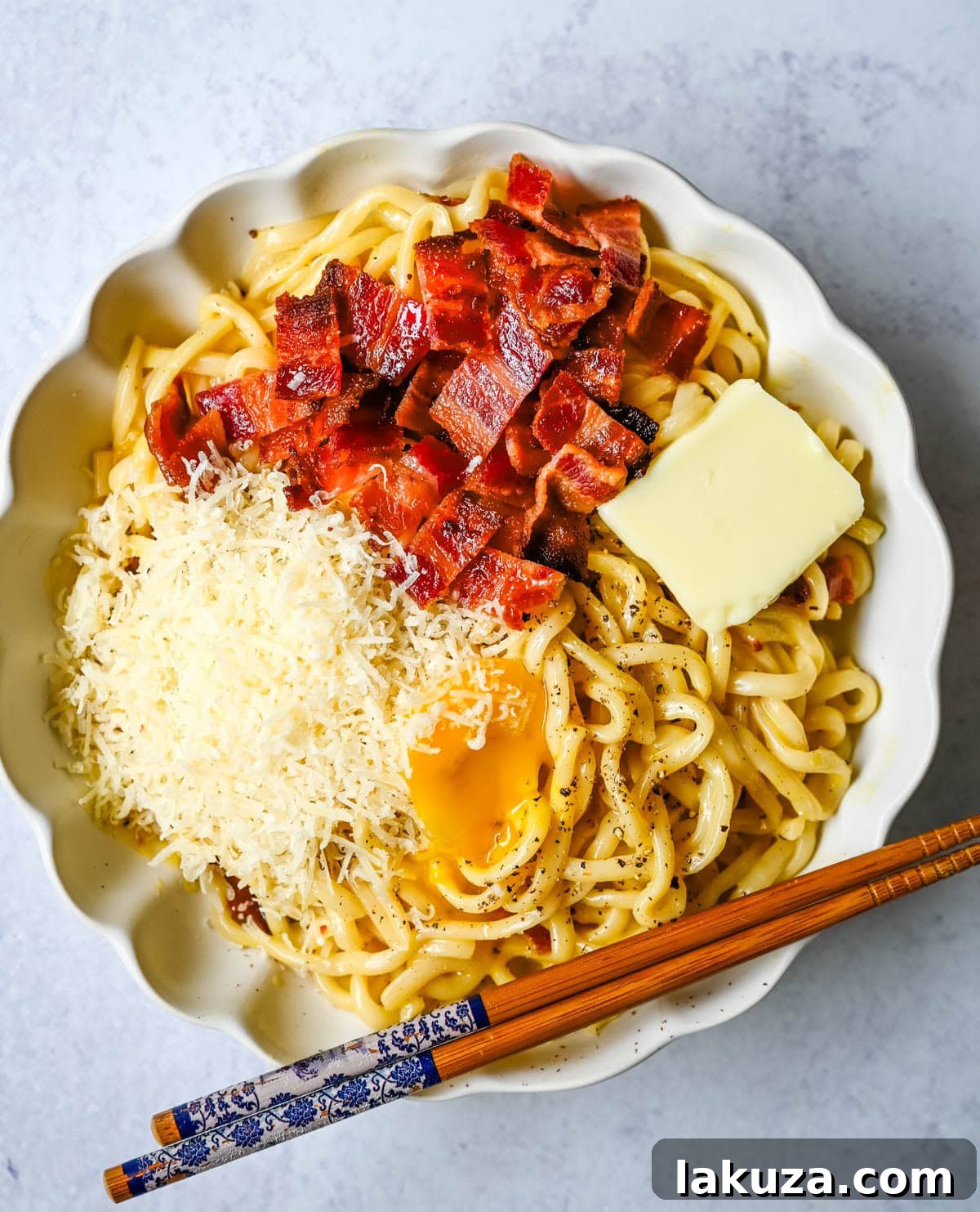 Japanese-Style Carbonara Udon with Bacon and Egg 3 Carbonara Udon close-up: glossy noodles with bacon and cheese.
