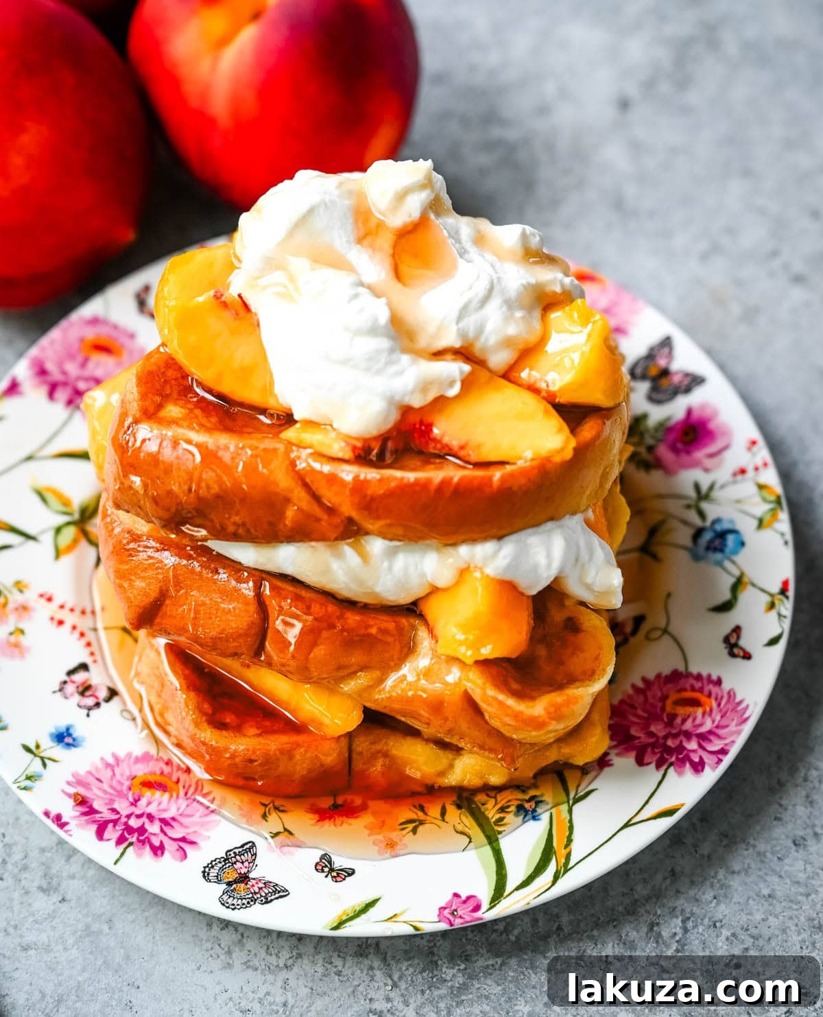 Stacked peach French toast with whipped cream and maple syrup