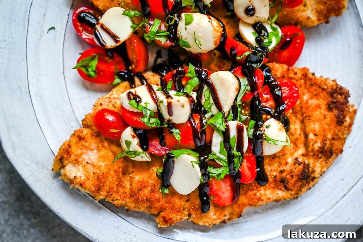 Crispy Caprese Chicken is crispy panko-crusted chicken topped with a fresh grape tomato and mozzarella caprese salad, finished with balsamic glaze. A simple, restaurant-worthy dinner ready in 30 minutes.