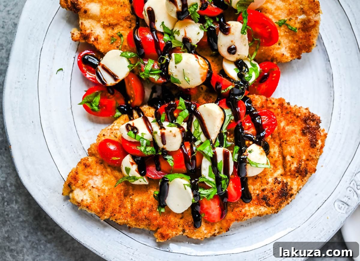 Crispy Caprese Chicken is crispy panko-crusted chicken topped with a fresh grape tomato and mozzarella caprese salad, finished with balsamic glaze. A simple, restaurant-worthy dinner ready in 30 minutes.